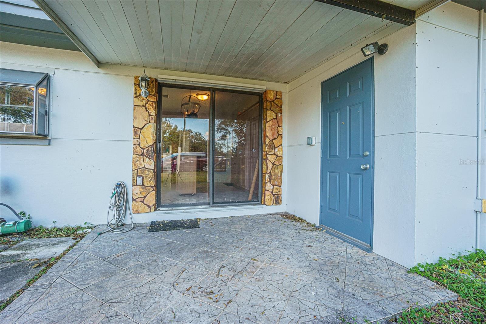 Covered porch with access to kitchen and garage.