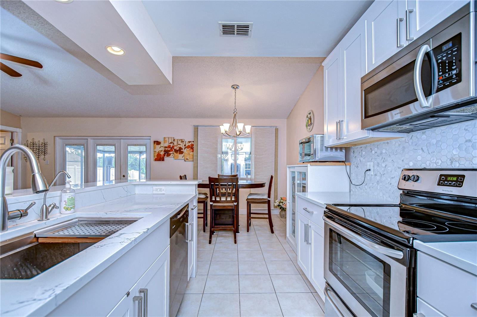 Breakfast bar with seating, gorgeous tile backsplash and beautiful counters!