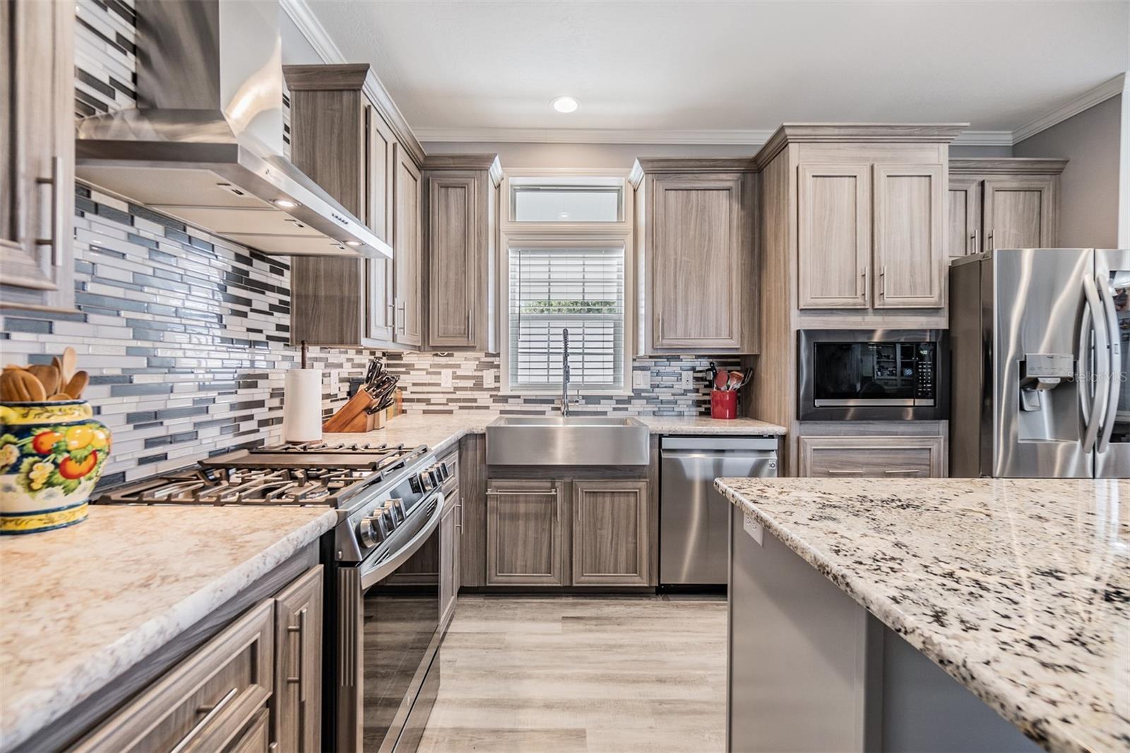 Gas Range, Stunning backsplash, farmhouse sink and custom vent hood add to the charm of this Chefs Kitchen!