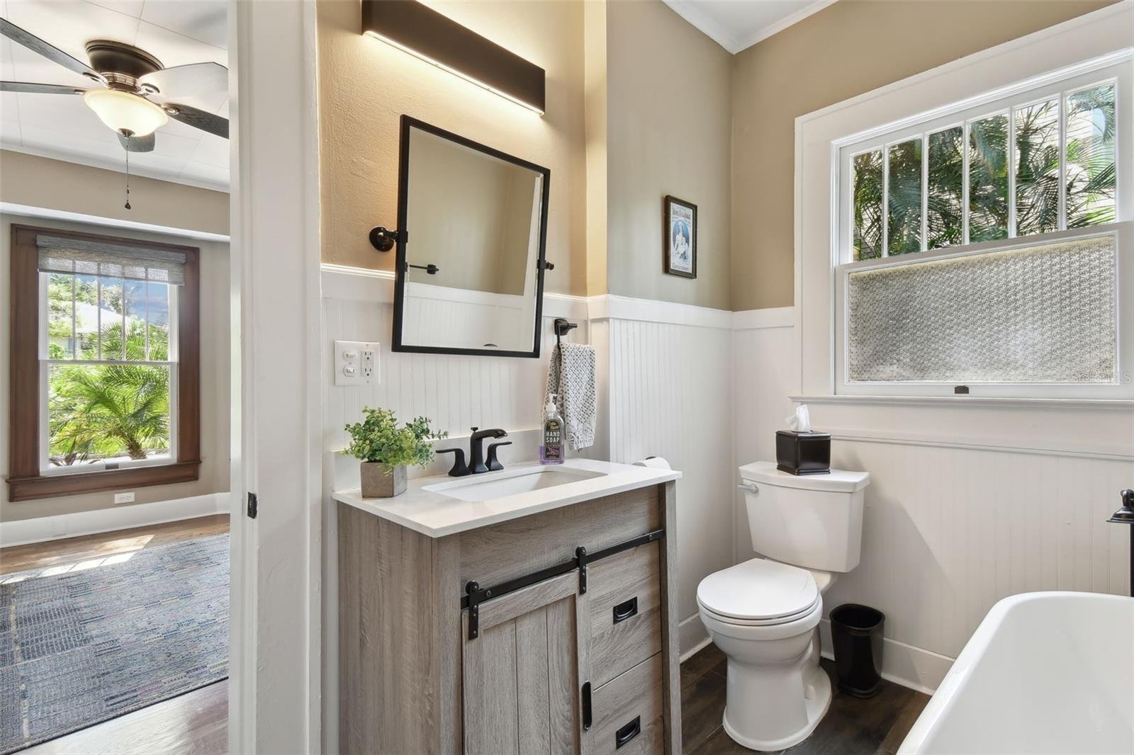 Renovated downstairs bath room with original wainscotting and shower tub.