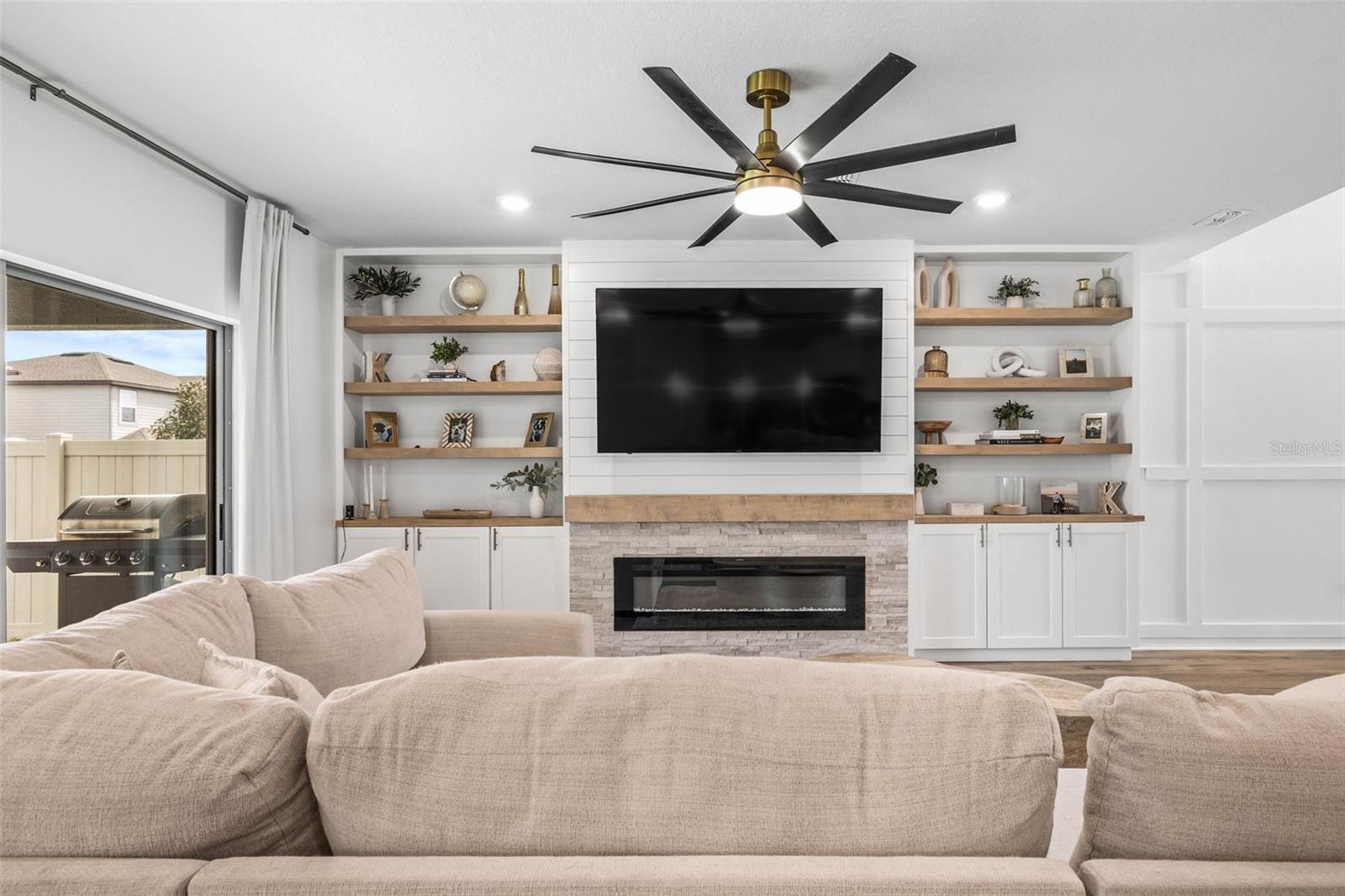 The living room opens up through the sliding glass doors to the lanai and back yard.