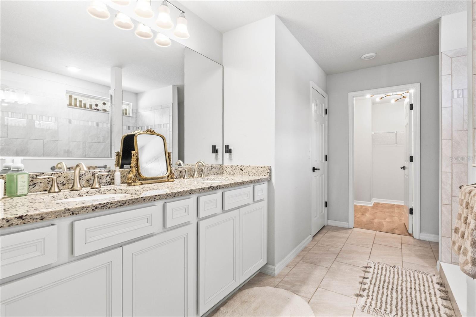 Primary ensuite bath with dual sinks, huge walk-in closet,