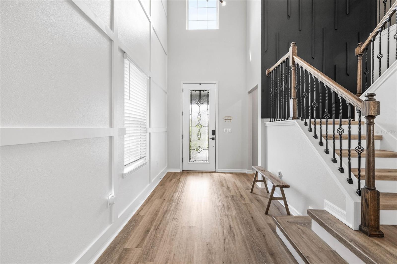 The two-story foyer is adorned with moulding throughout, new lux vinyl flooring, and abundant natural light.