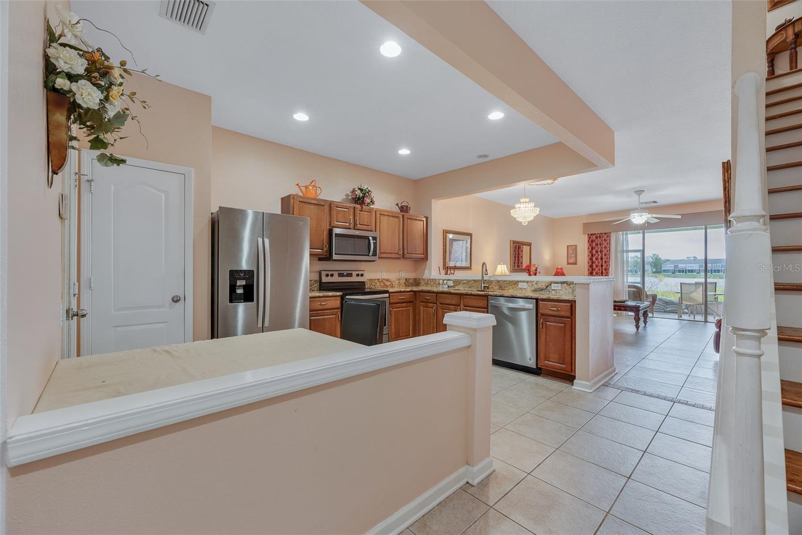 Inside the front door, is the kitchen/living room with a half bathroom, stairs to the second level, and access to back patio and garage.