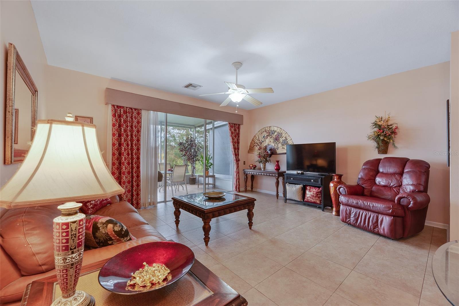 The spacious living room has been upgraded with porcelain tiles that lead out to the back screened-in porch to enjoy the water views.