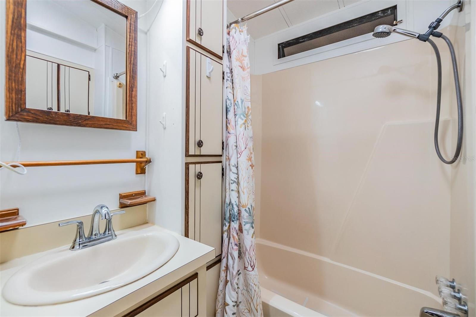 Bath with tub and shower surround.