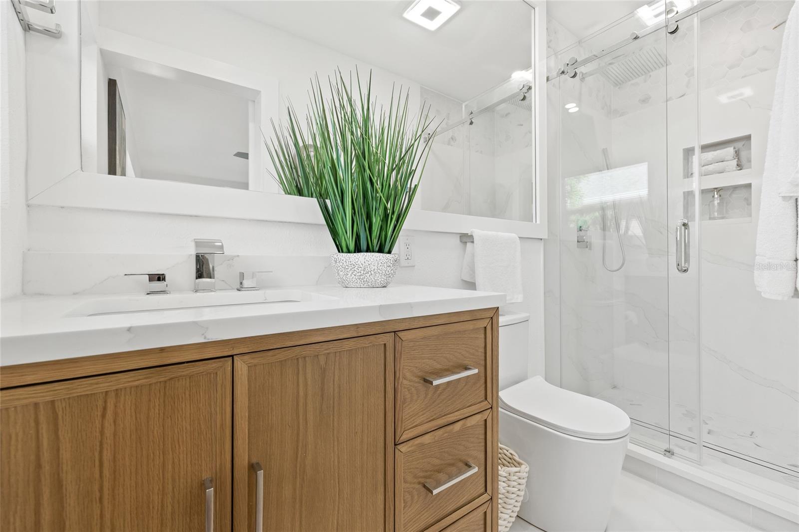 Primary Bathroom- Quartz shower walls with matching vanity countertop!