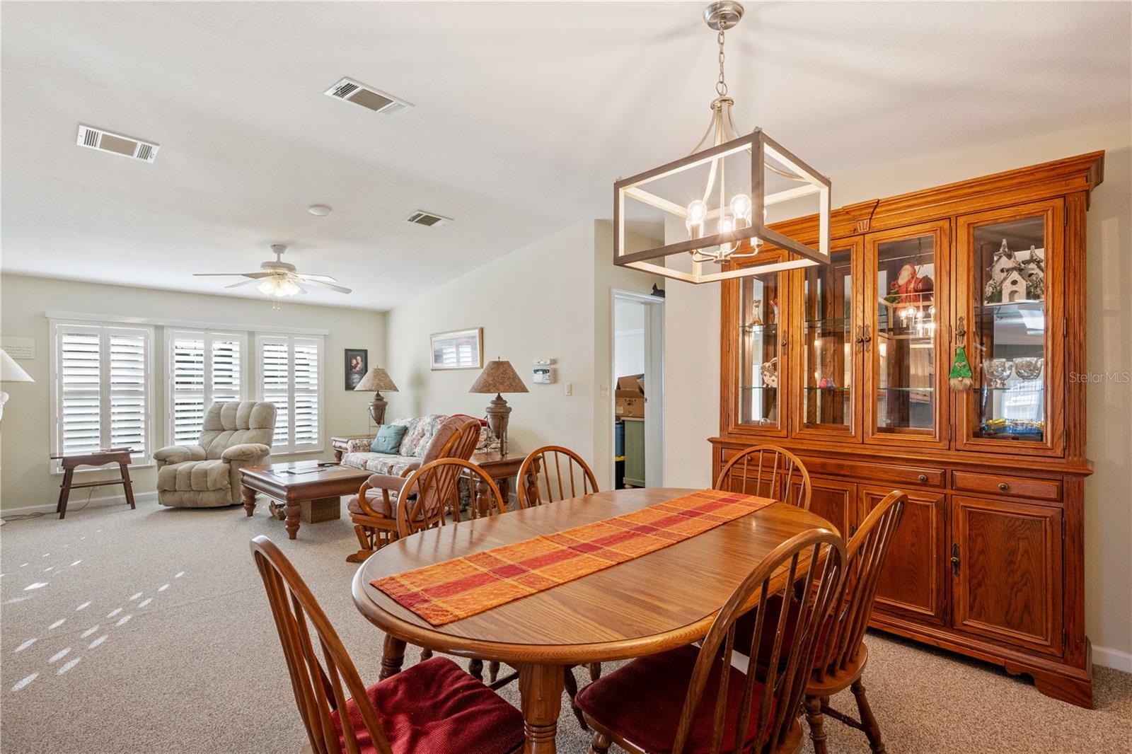 Plantation shutter, ceiling fan are part of this living room area.