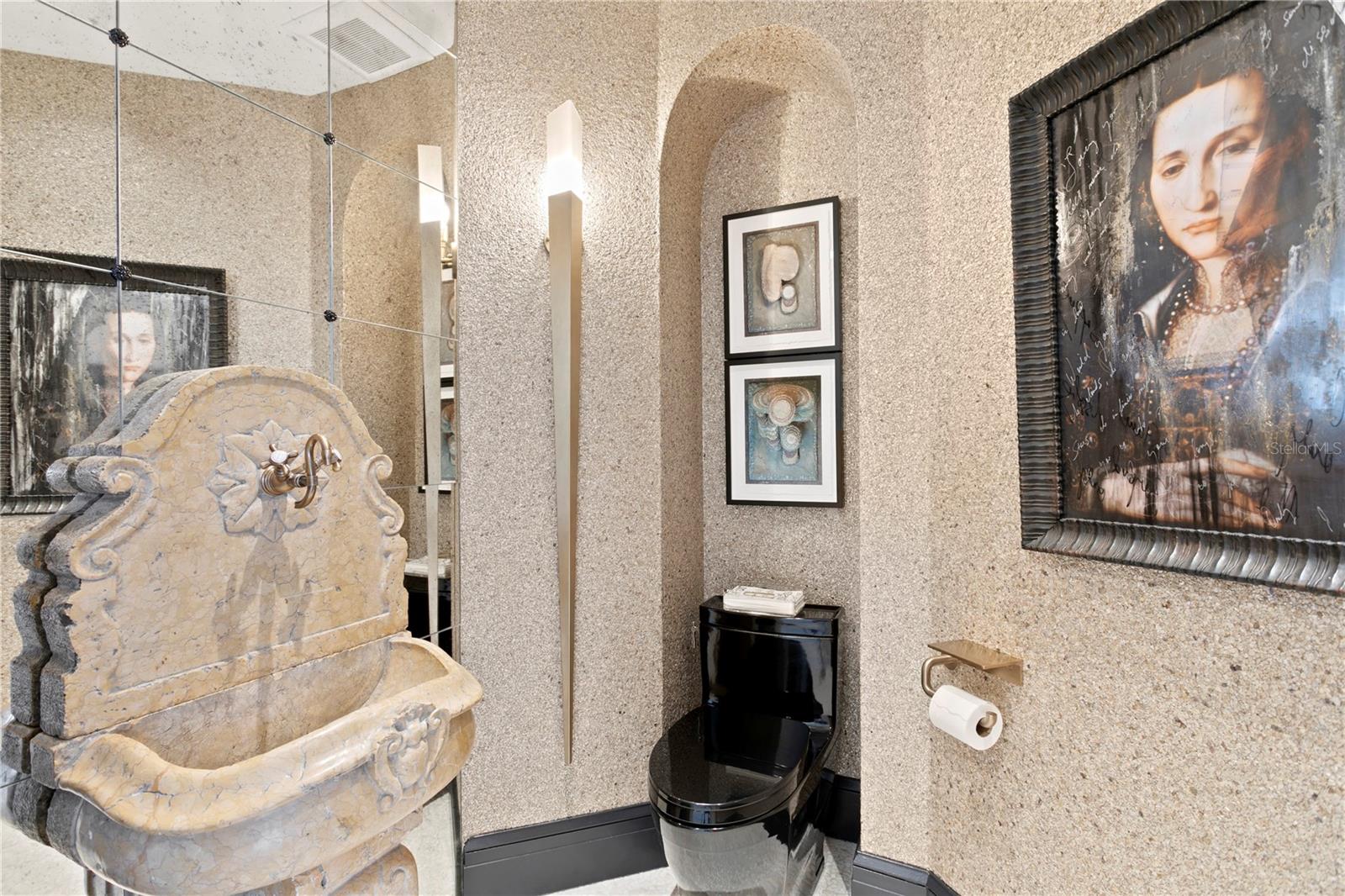 The sink from a converted French fountain offers a unique experience in the powder bathroom