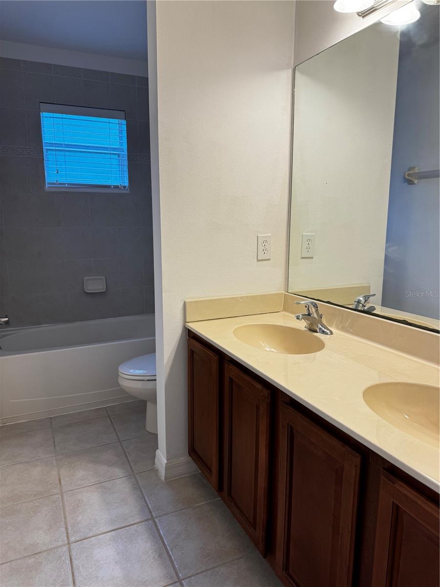 Jack and Jill bathroom connected to two bedrooms with double sinks