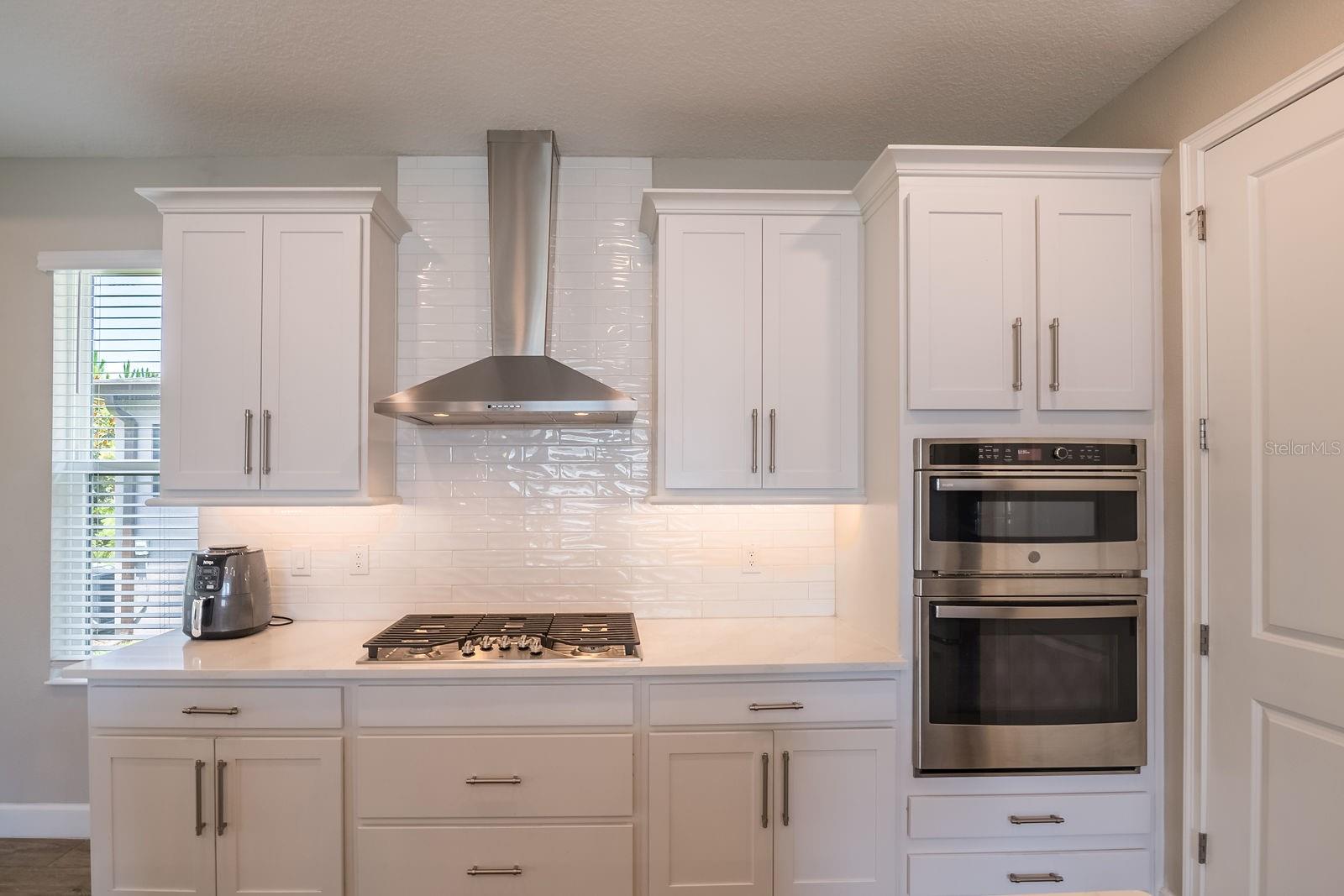 Double ovens and range top with vent.