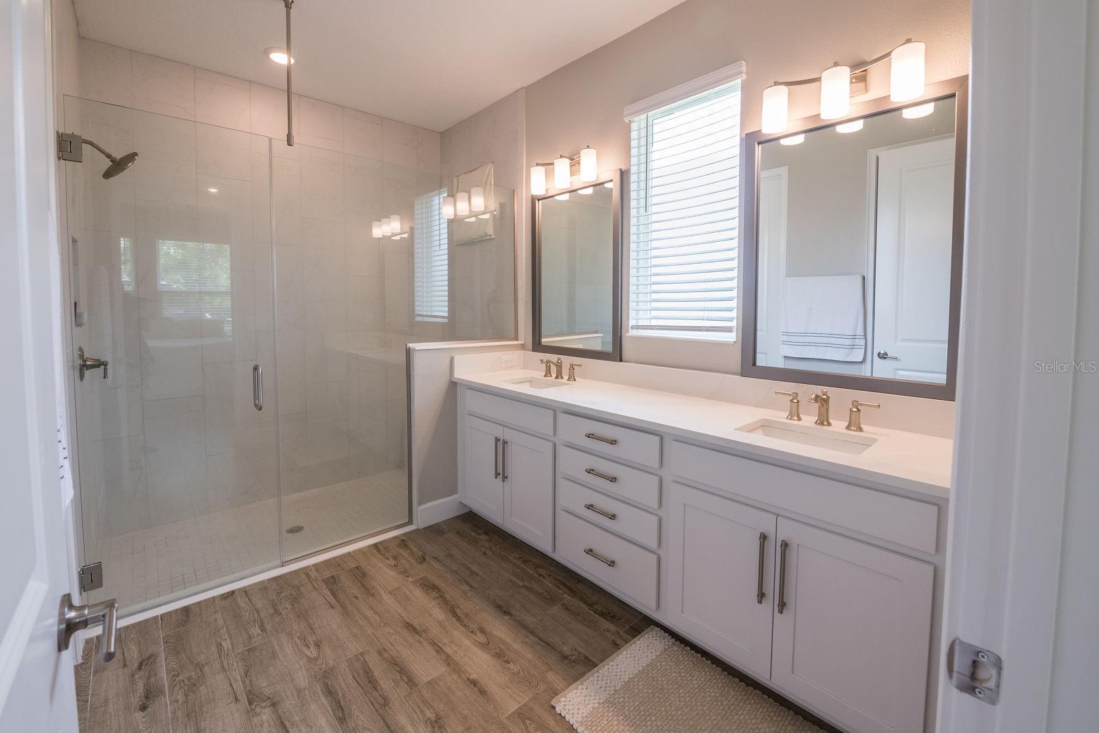 Dual sinks an walk in tiled shower.