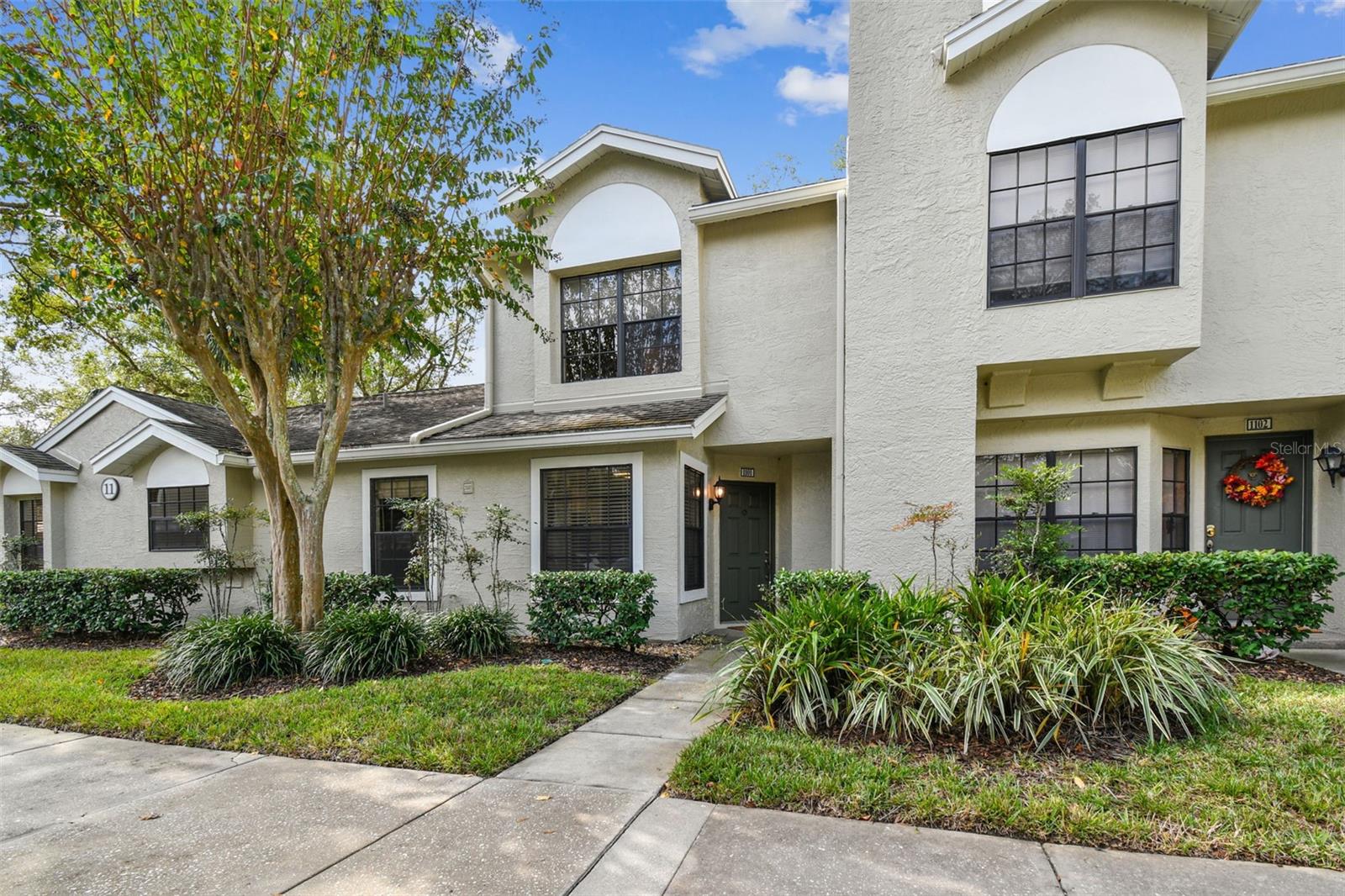 Lush landscaping surrounds the building and the community.