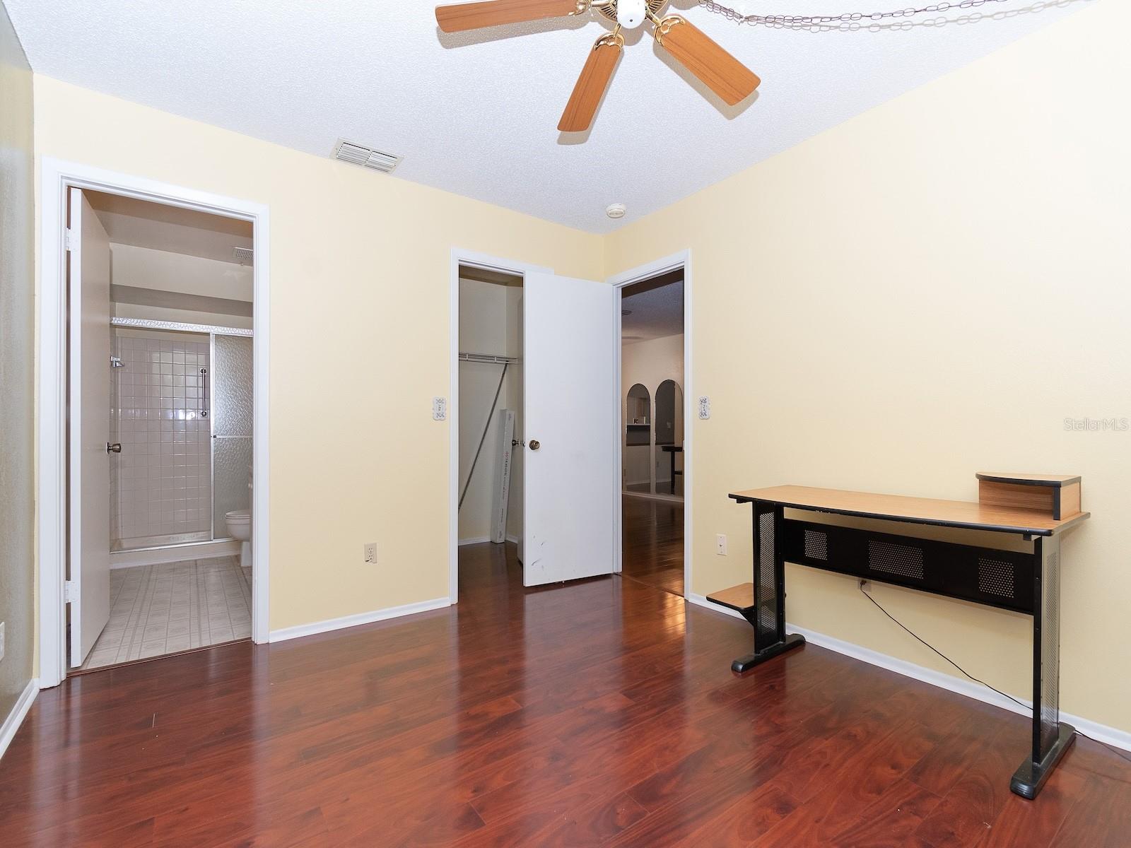 Primary bedroom with a walk-in closet and ensuite bath featuring a walk-in shower