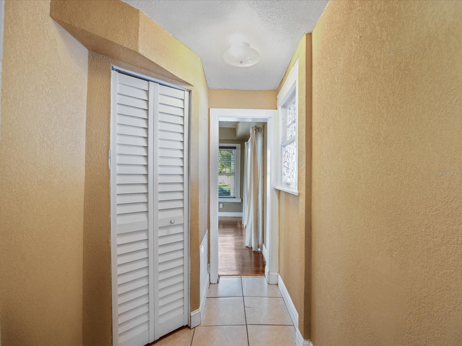 Wide hallway connecting kitchen and living room at back of house provides extra space for storage, litter box, pet crates, etc.