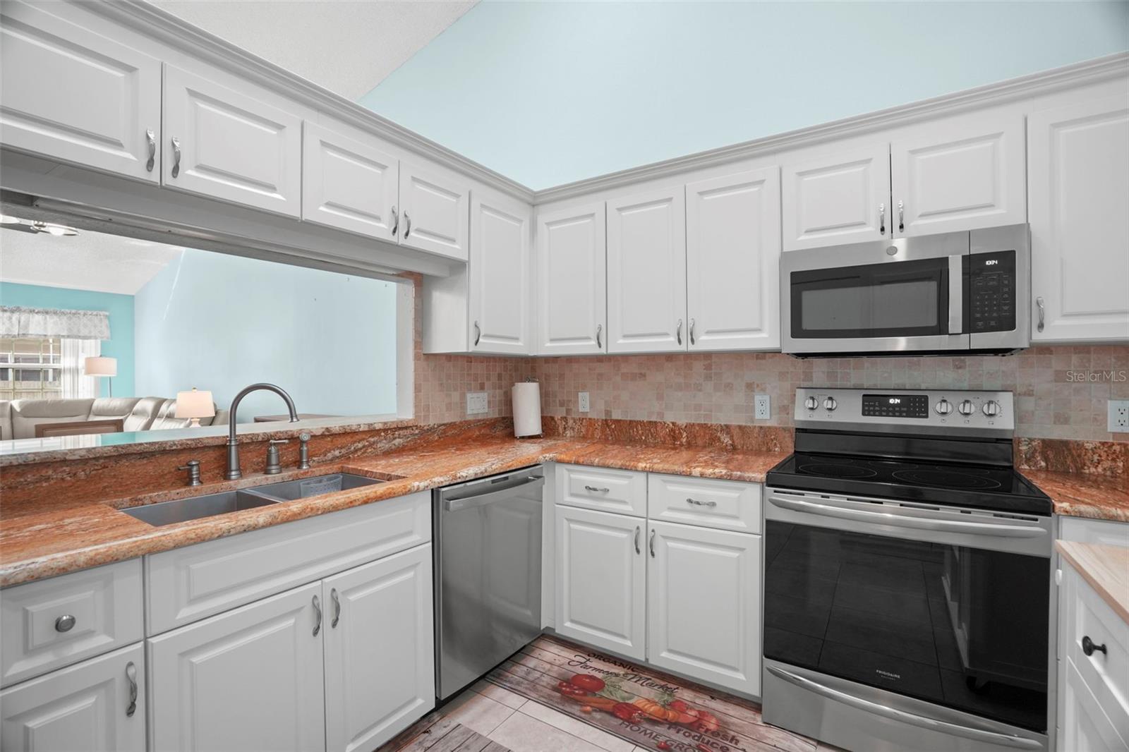 The kitchen features granite countertops, modern cabinetry, a skylight and recessed lighting, extra pantry storage and newer stainless-steel appliances.