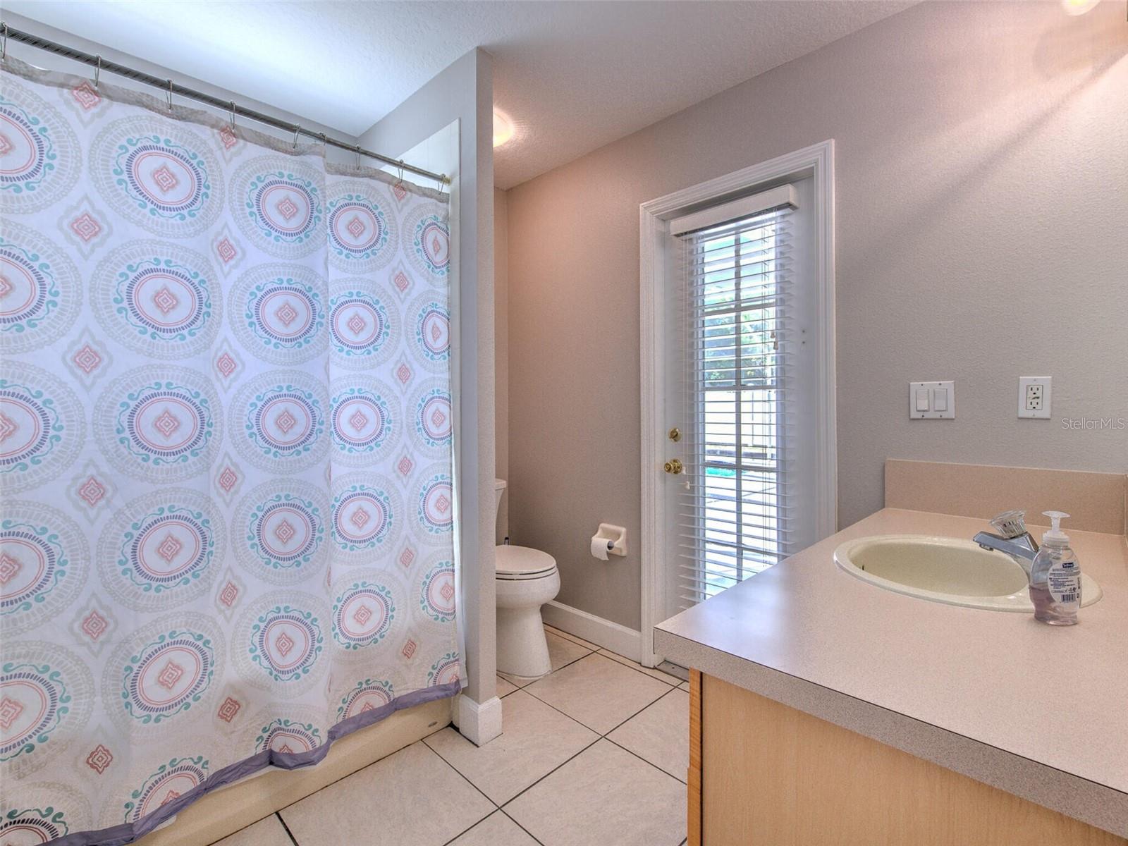 Back guest bathroom with door to lanai / pool