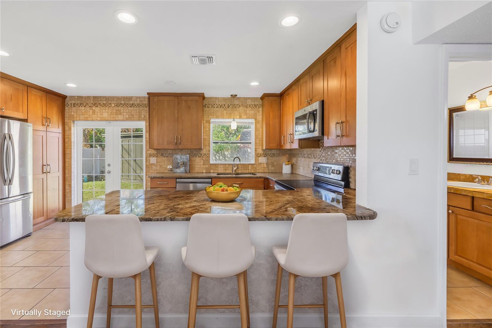 Virtaully staged kitchen and bar stool seating.