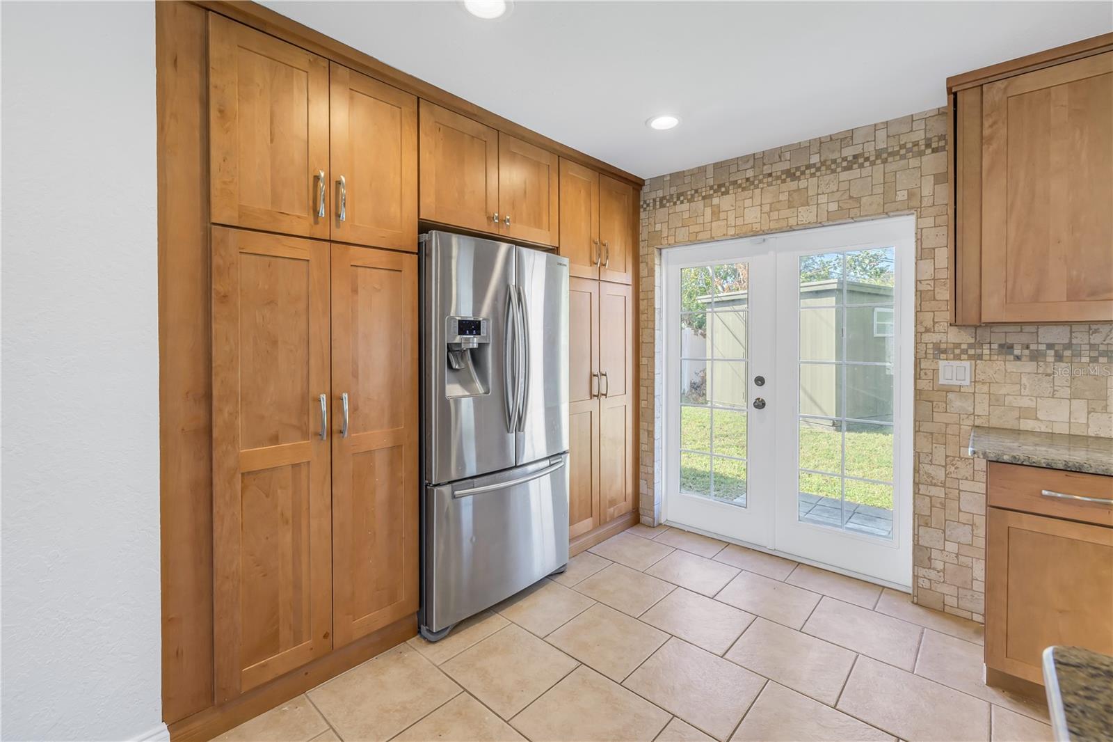 Kitchen double doors lead to the back yard.