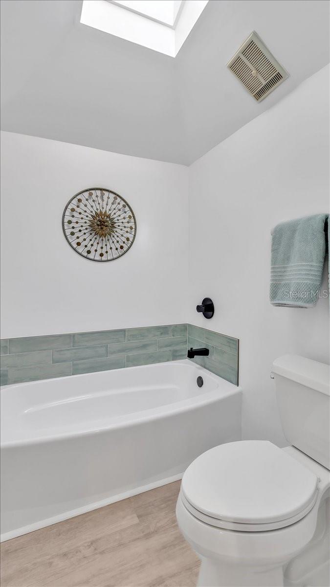 Fully renovated master bathroom with luxury vinyl and new skylight.