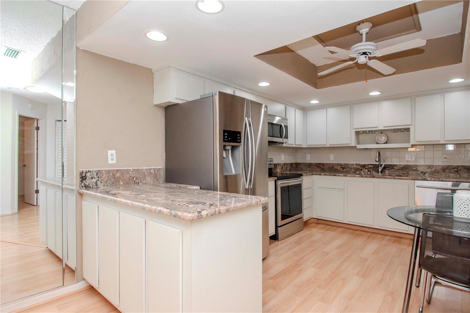 View into the kitchen.  Stainless appliances and granite countertops.