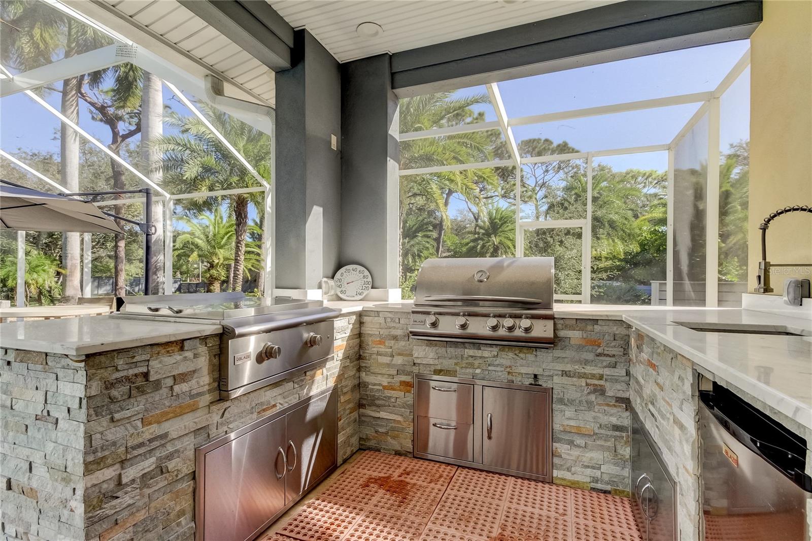 Outdoor kitchen with Blaze gas grill and separate flat top.