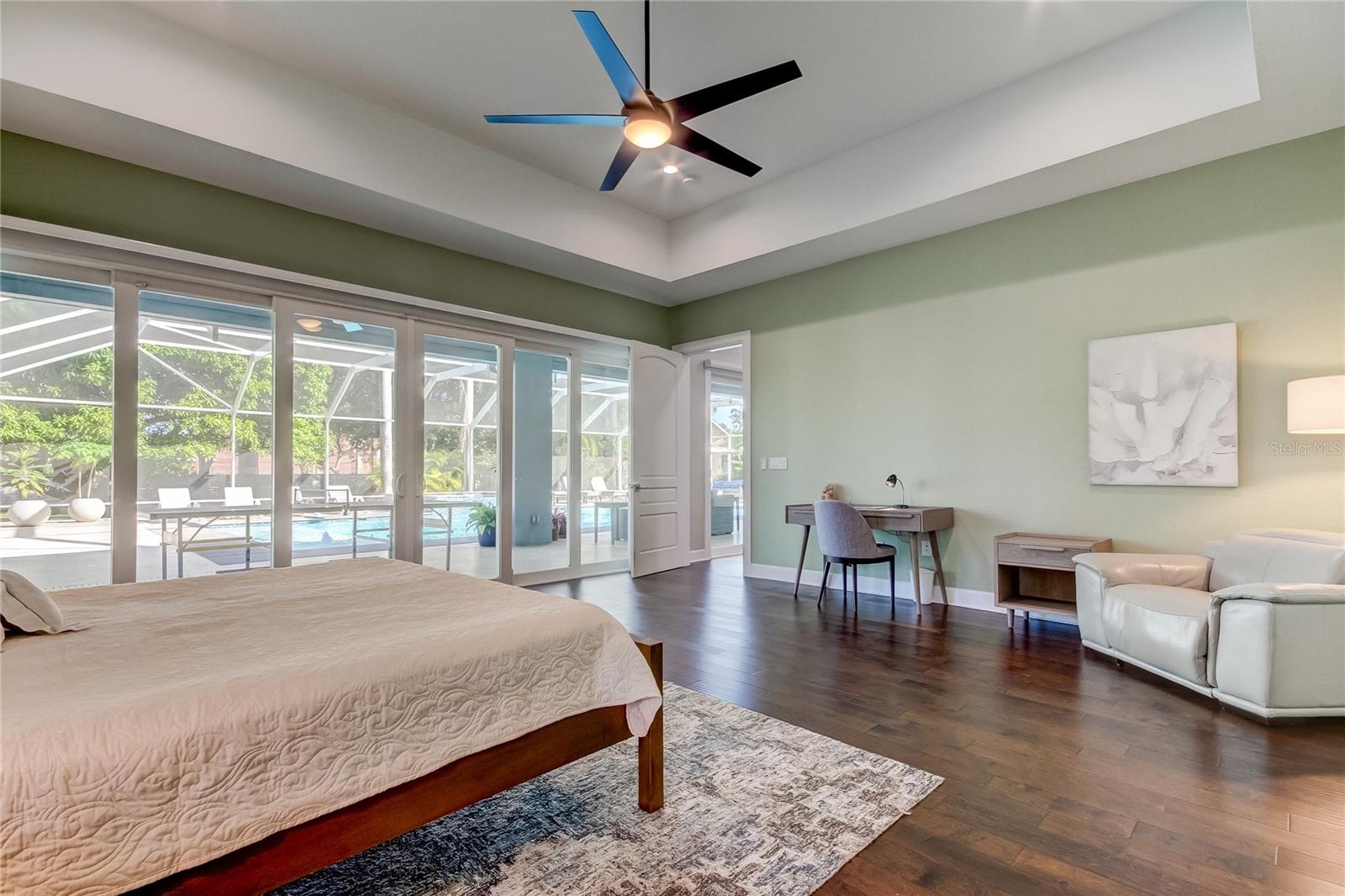 Primary bedroom suite with sitting area, overlooking pool