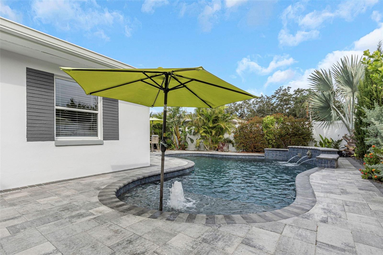 Pool includes a sun shelf with umbrella holder