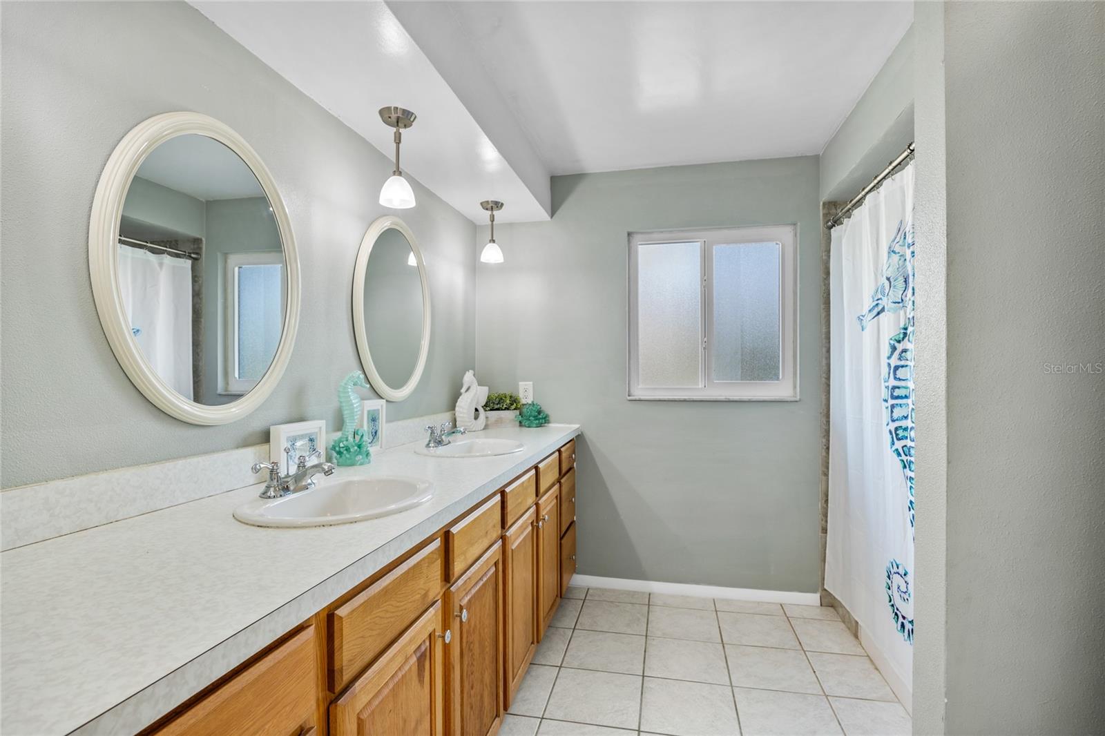 The Guest Bathroom has a large double sink vanity and beautiful tiled shower/tub combo.