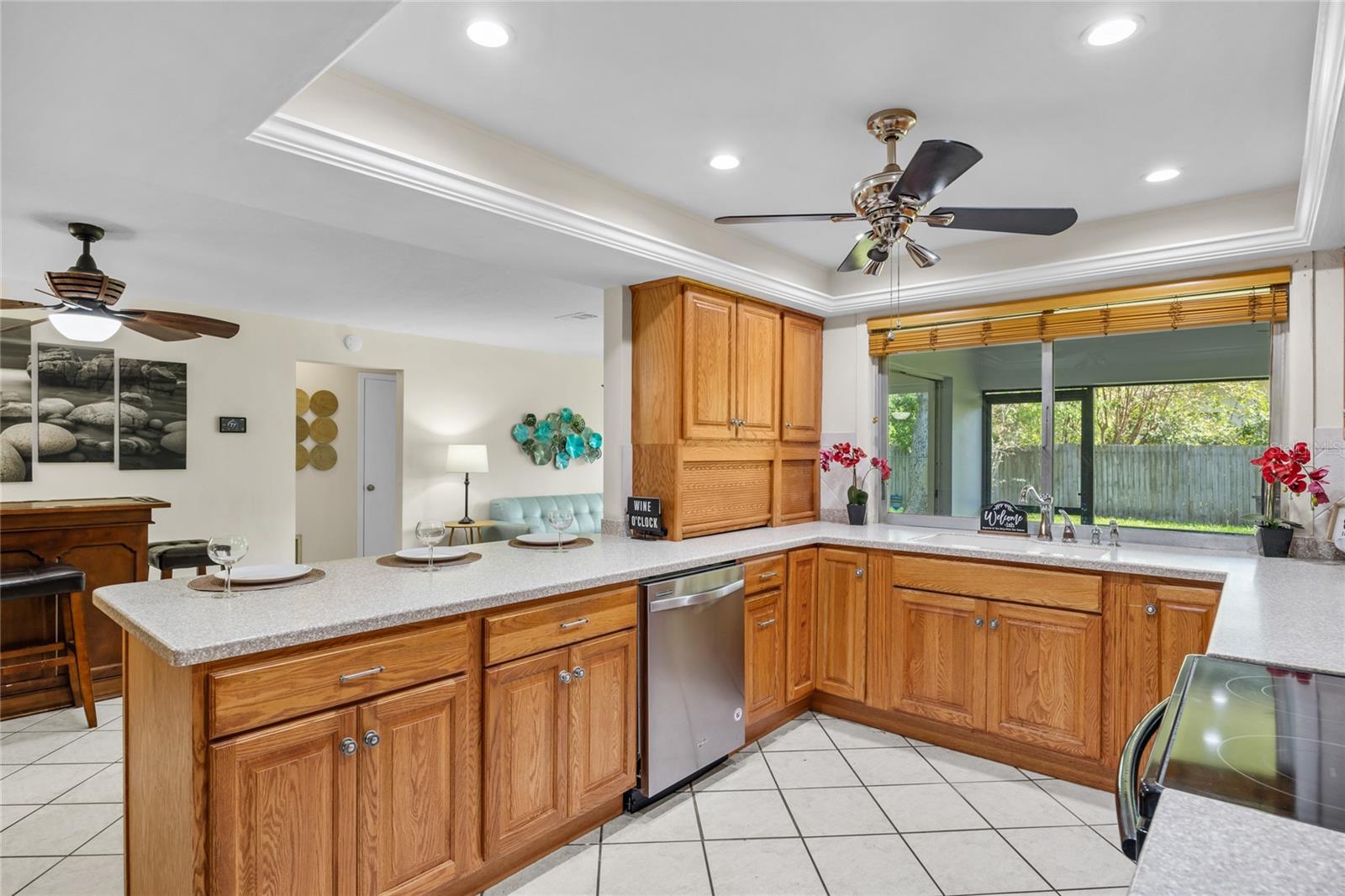 The expansive kitchen features a breakfast bar, a convenient pass-through window to the lanai, and an appliance garage for added organization and style.