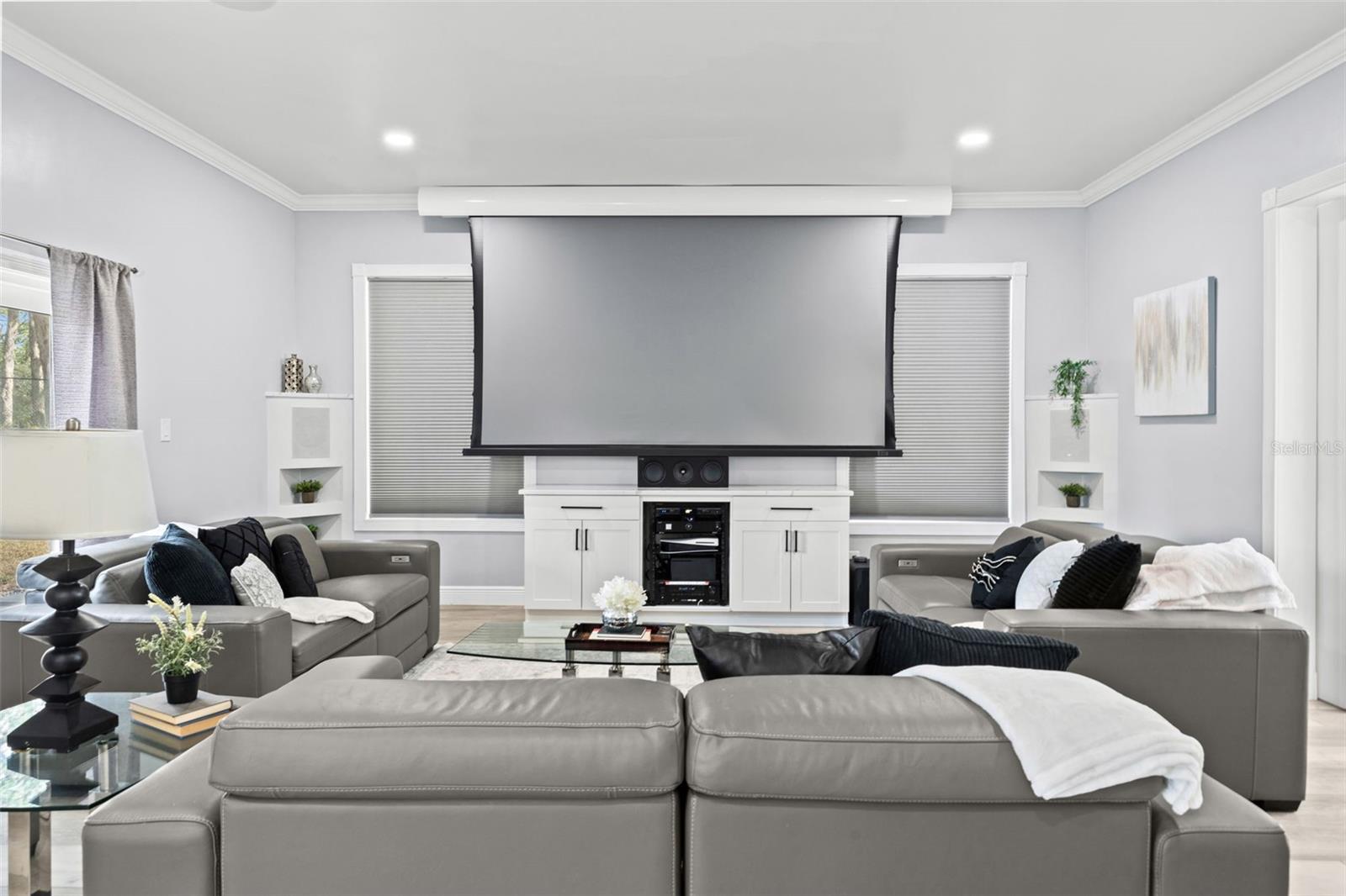 Living Room with built in speaker and sliding doors that lead to the pool and backyard oasis