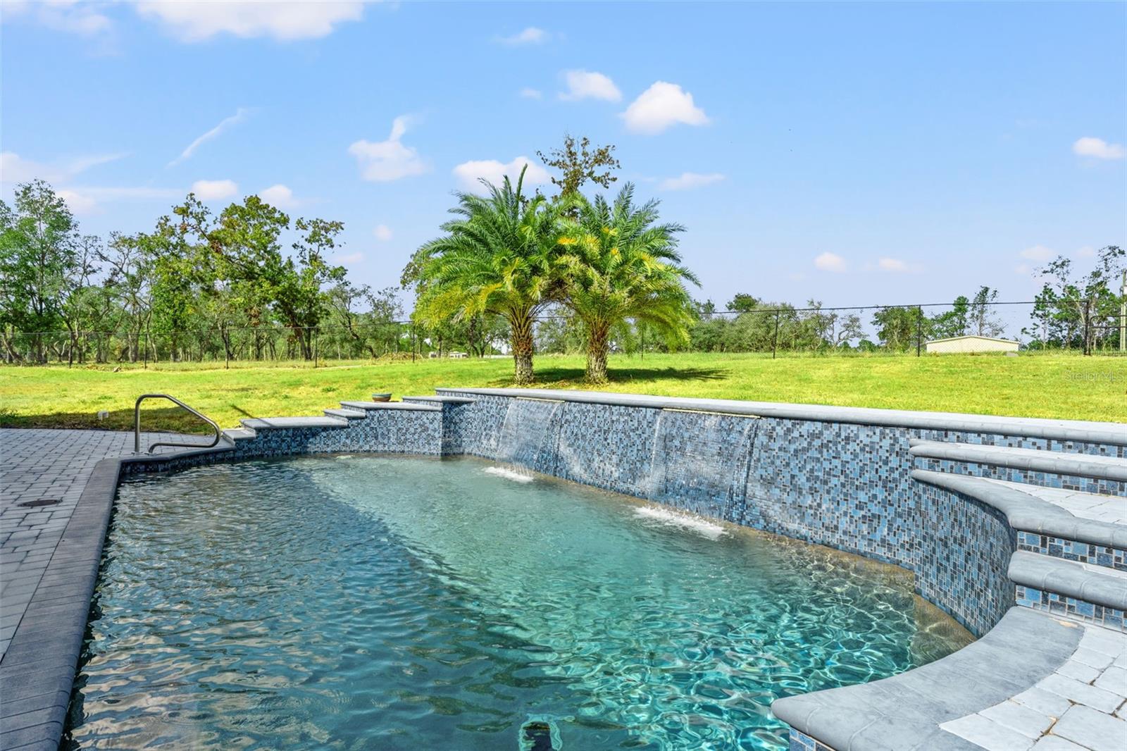 Heated Pentair pool with a tranquil waterfall