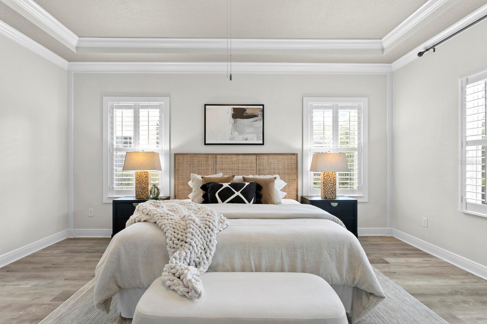 The tray ceilings and crown molding make the primary suite an elegant space