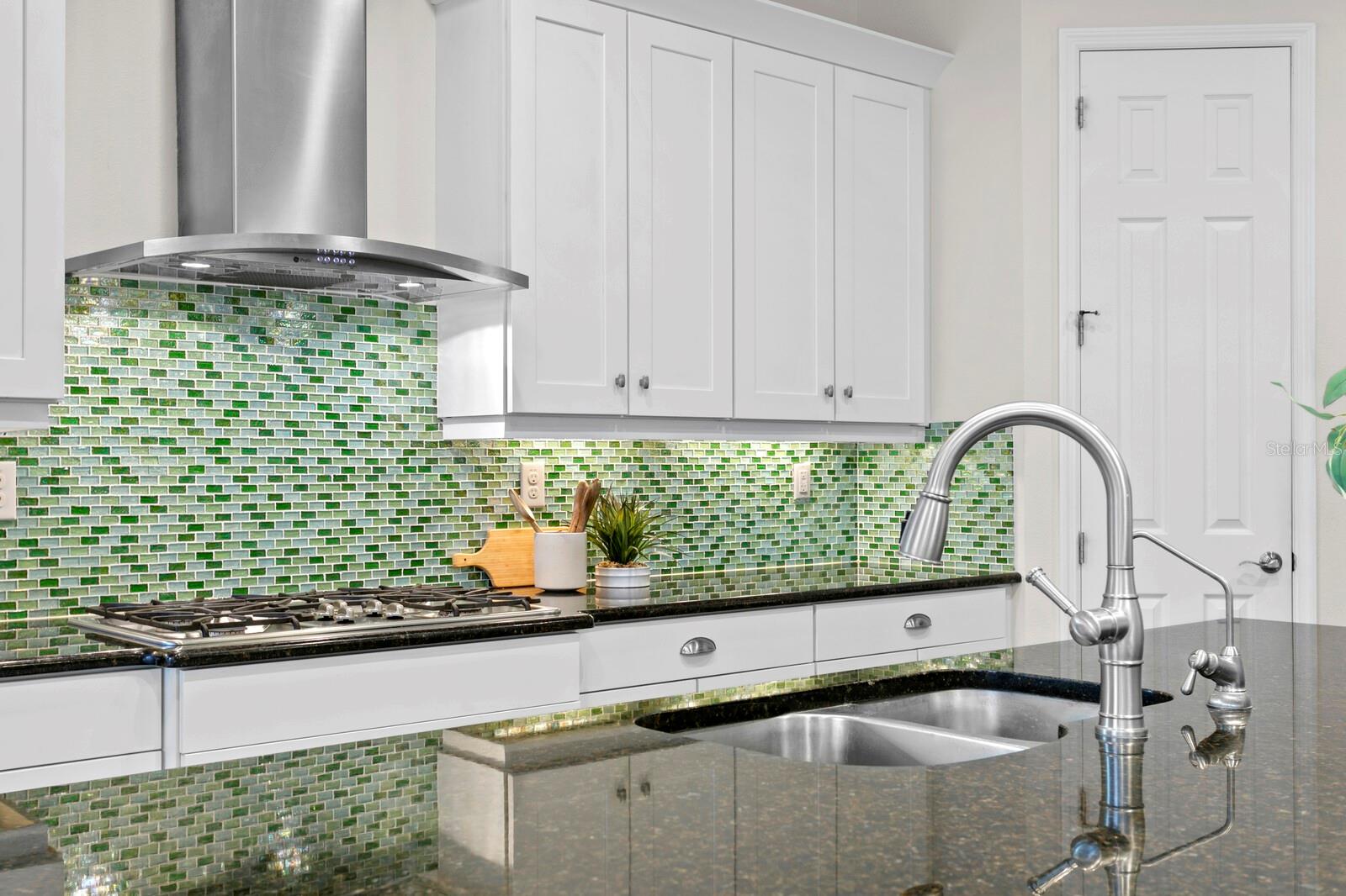 The undercabinet lighting makes the glass tile backsplash sparkle