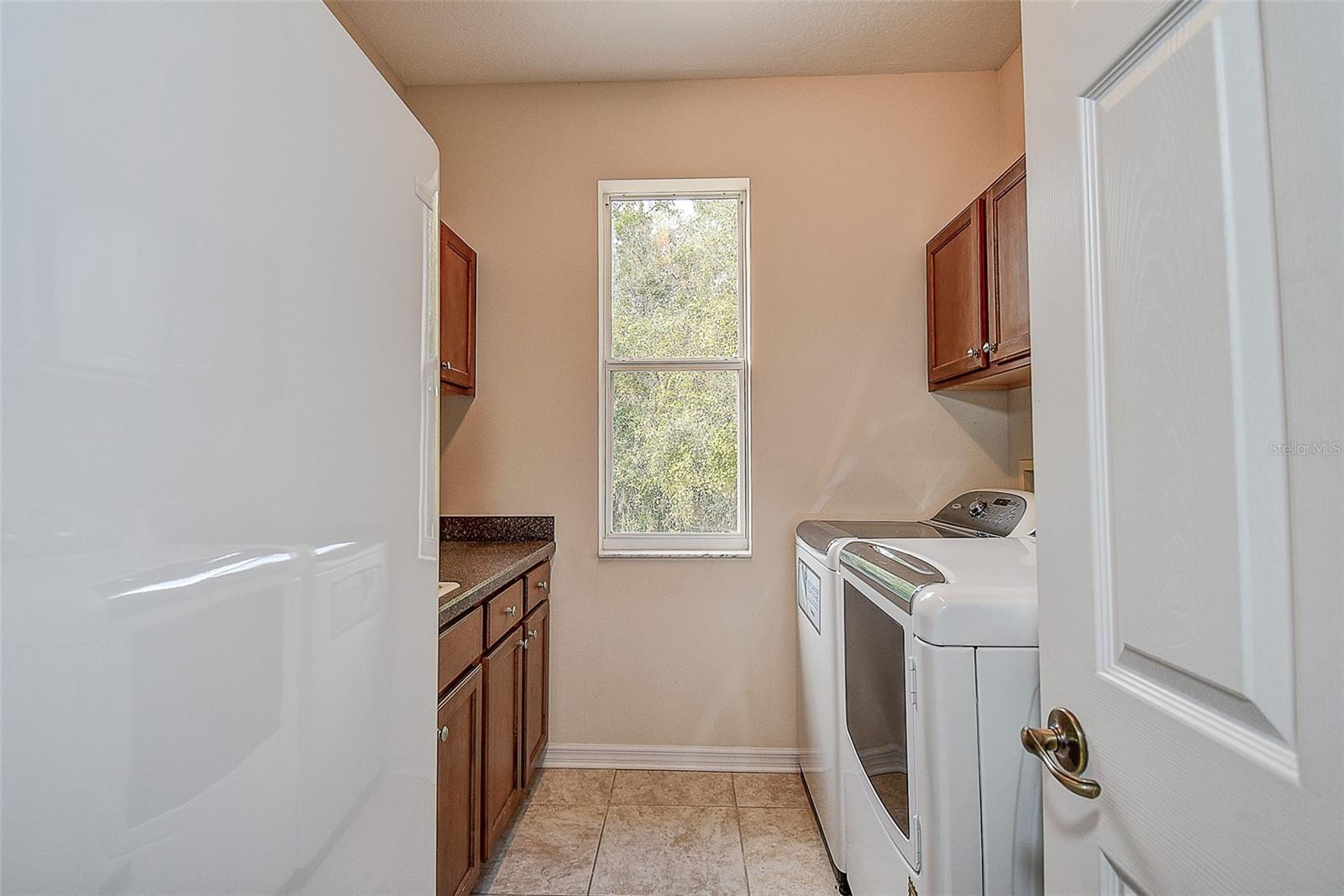 Inside Laundry room with stand alone freezer, washer and dryer