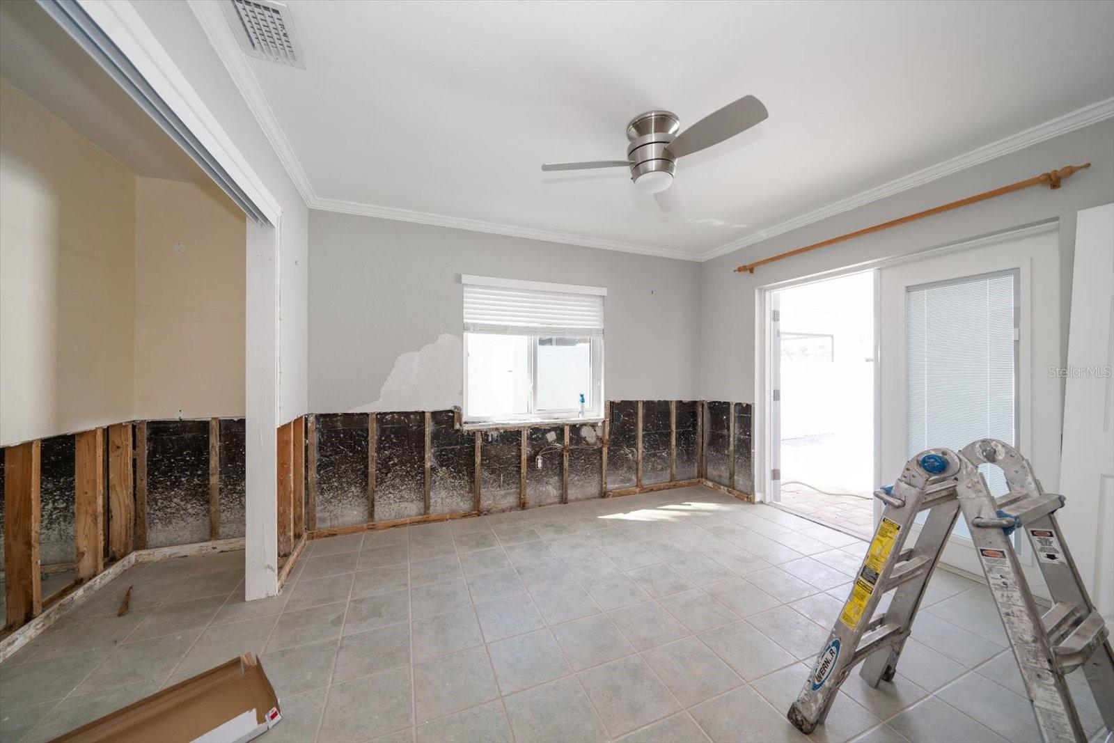 Back bedroom with hurricane impact doors leading to back patio and pool. Drywall to be installed, textured and painted.