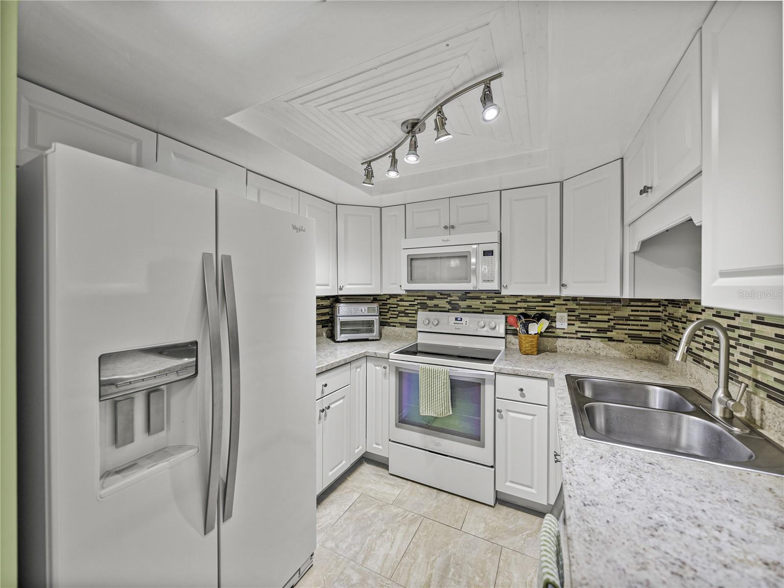 Newer wood cabinetry with updated appliances, countertops & lighting~