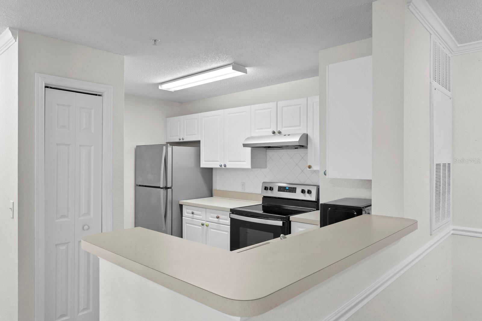 The kitchen includes a white tile backsplash