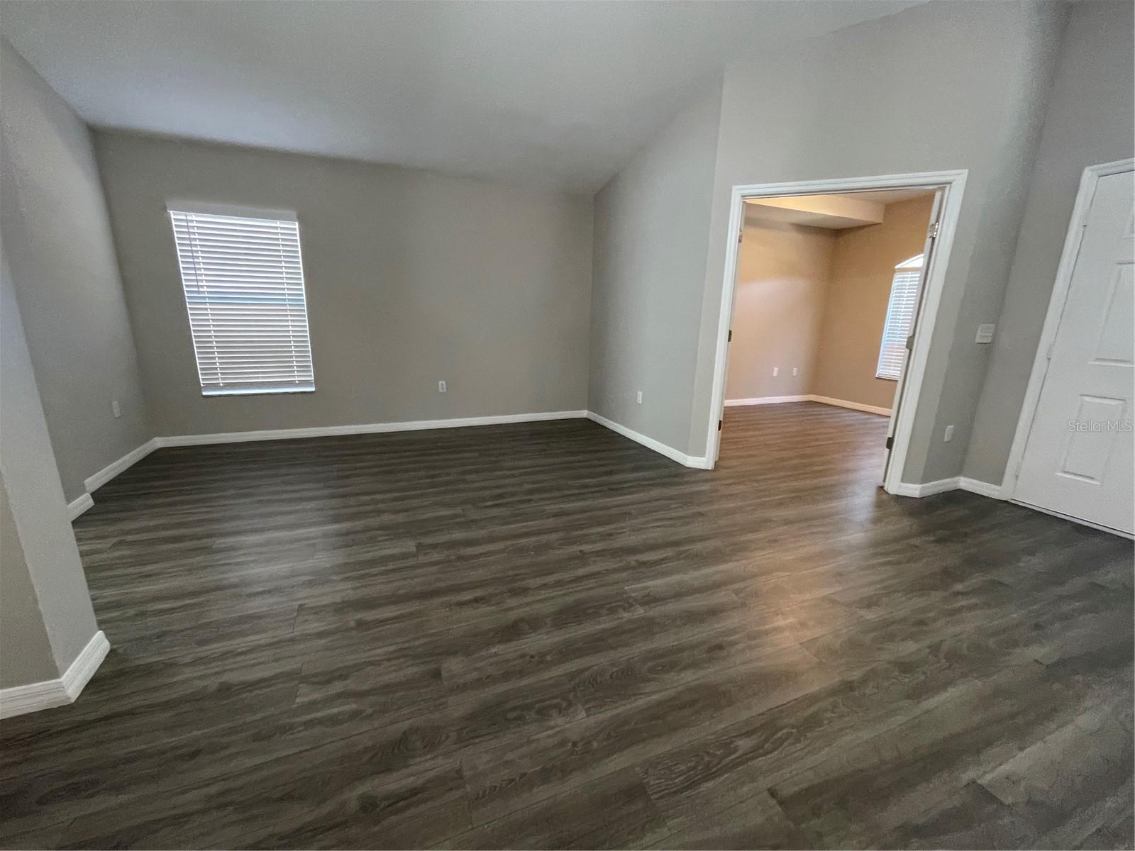 Open concept formal living room with home office or den at entry