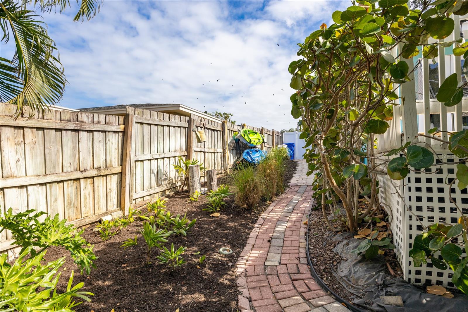 This side yard has a brick paver walk way and has additional space for storing kayaks and other items.