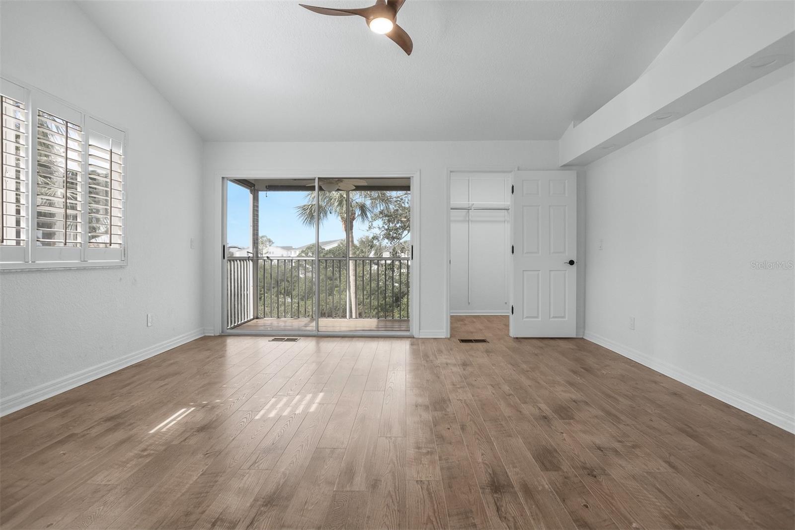 Wide open Primary Bedroom with high ceilings and ceiling fan, double closets and private balcony over the lake on third floor