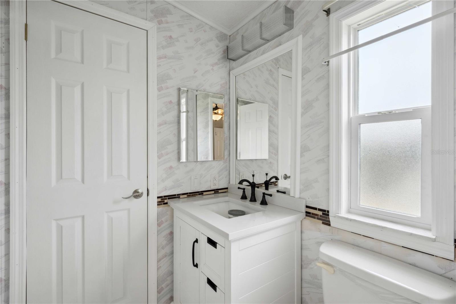 Guest bath has step-in shower and updated vanity.