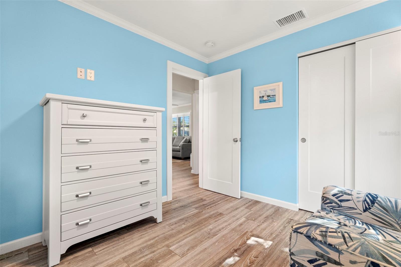 Guest bedroom with solid wood closet and entry door.