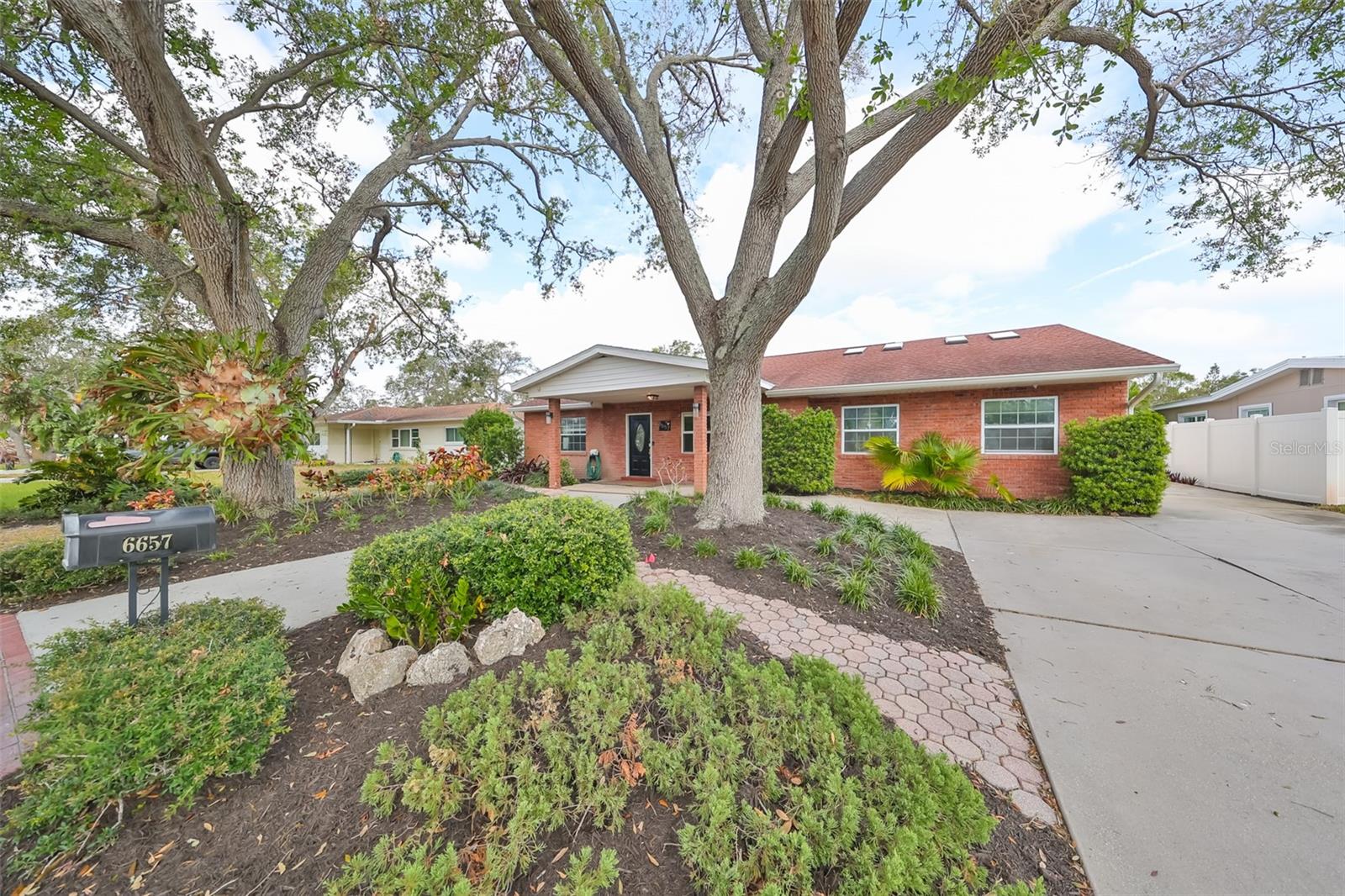 Mature landscaping with grand oak trees flanking the property.