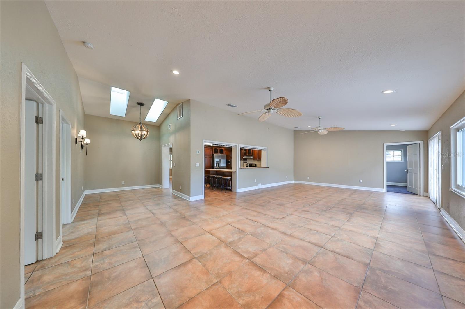 View of the expansive Great Room with kitchen in the middle and door to the Gym ( Bedroom #4)