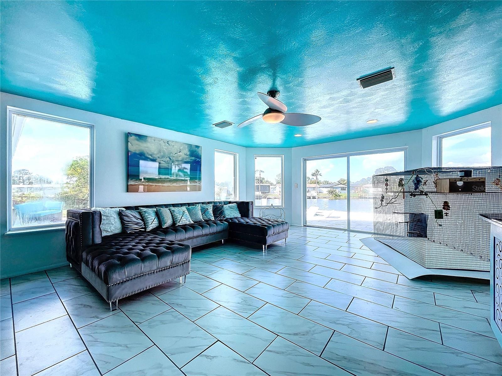 Spacious living room with views of the pool and waterfront.