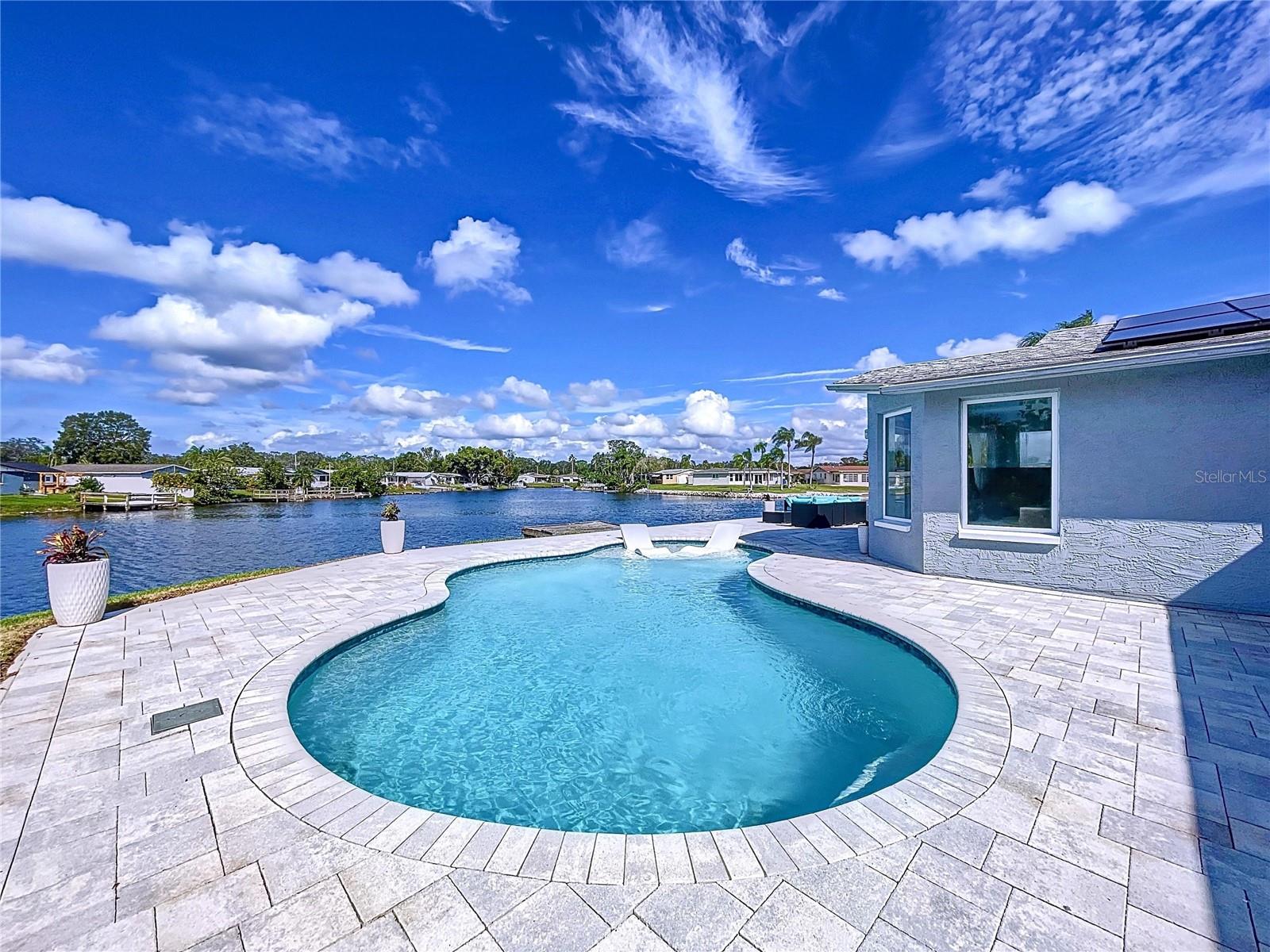 Large pool deck with pavers offers plenty of room to entertain guest.