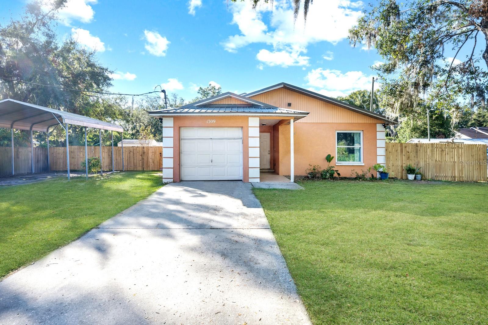 An 18X20 Covered Carport with a Double Gate Entrance into the Backyard.