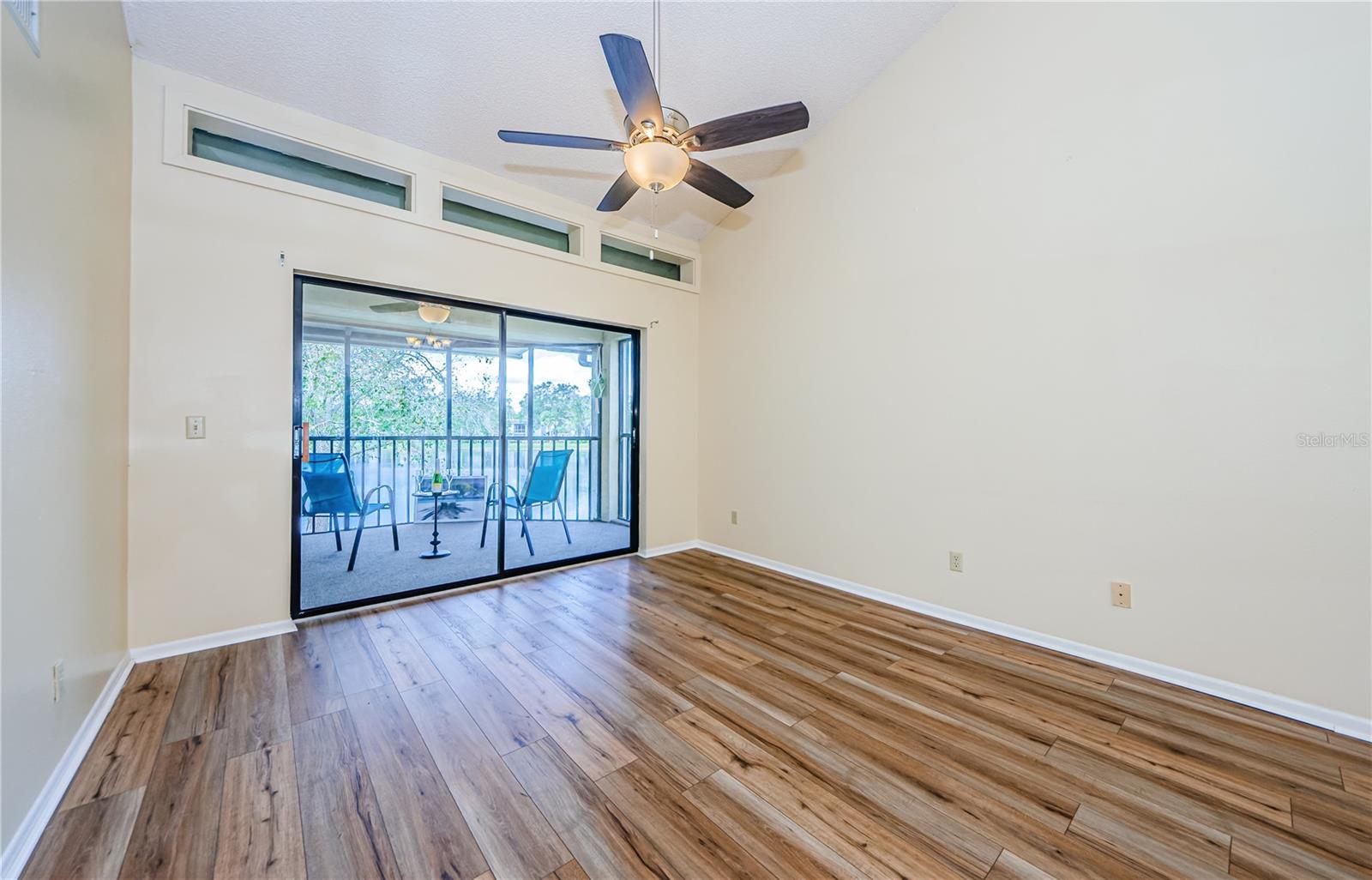 Livingroom with high vaulted ceiling, luxury laminate flooring and skylights for additional natural lighting.