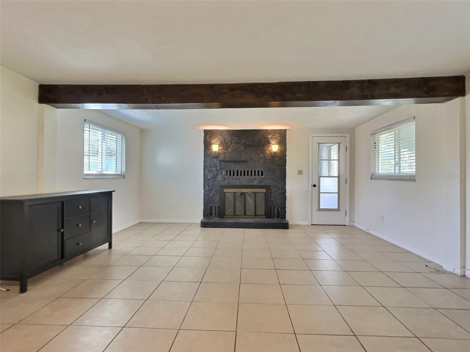 Enormous family room with fireplace and door to back porch area